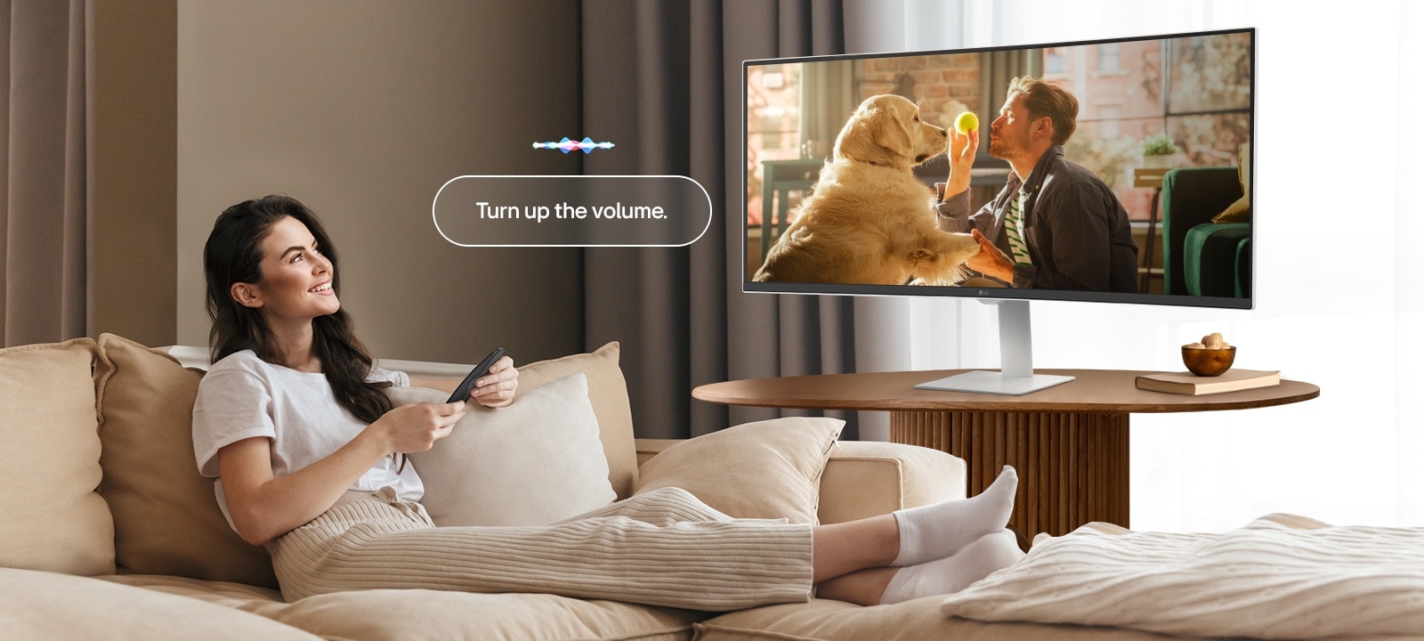 Nainen lisää LG Smart Monitor -näytön äänenvoimakkuutta Magic Remotella.	