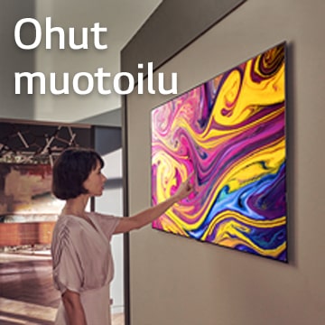 Nainen katselee seinälle ripustettua TV-kuvaa, jossa näkyy taidetta.