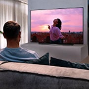 LG 77'' LG OLED 4K TV - CX, A couple sitting on a sofa in the living room watching a romantic movie on TV, OLED77CX6LA, thumbnail 10