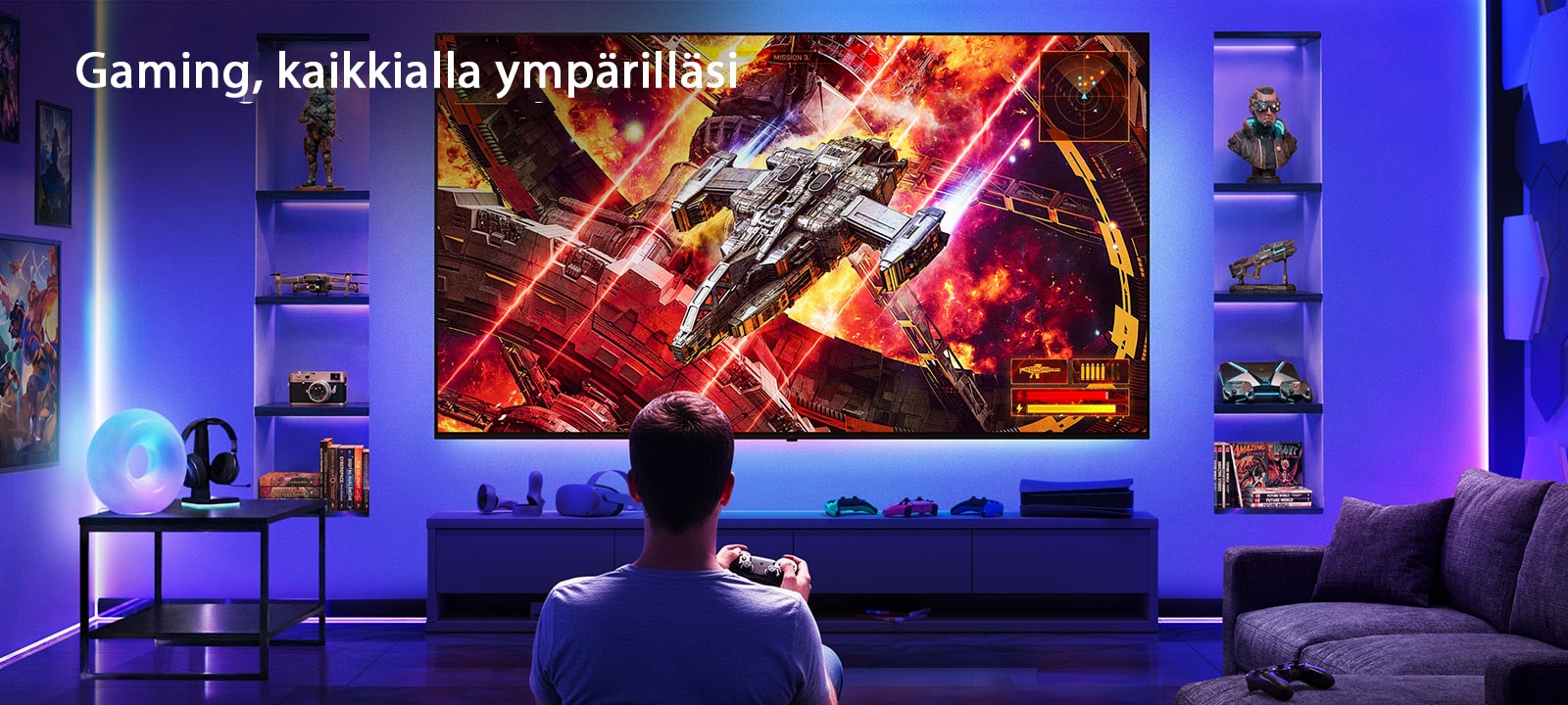 LG Ultra Big TV on seinäkiinnitetty neonvalaistussa pelihuoneessa, jossa suuri näyttö esittää elävää avaruustaistelukohtausta pelaajan istuessa ruutua vastapäätä, kuvastaen mukaansatempaavaa ja kiehtovaa pelikokemusta.
