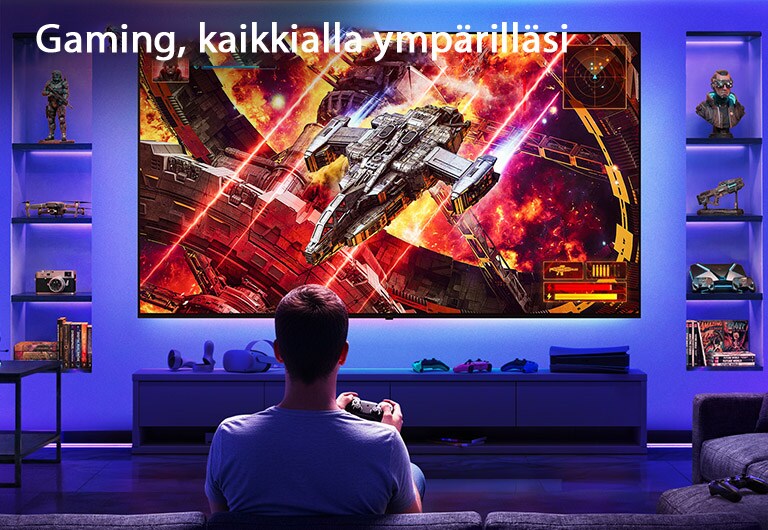 LG Ultra Big TV on seinäkiinnitetty neonvalaistussa pelihuoneessa, jossa suuri näyttö esittää elävää avaruustaistelukohtausta pelaajan istuessa ruutua vastapäätä, kuvastaen mukaansatempaavaa ja kiehtovaa pelikokemusta.