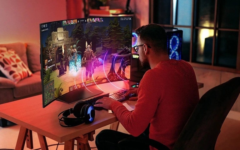 Un gamer en pleine immersion dans une scène dynamique sur un moniteur incurvé LG, démontrant comment un écran ultra-large améliore l’expérience de jeu.