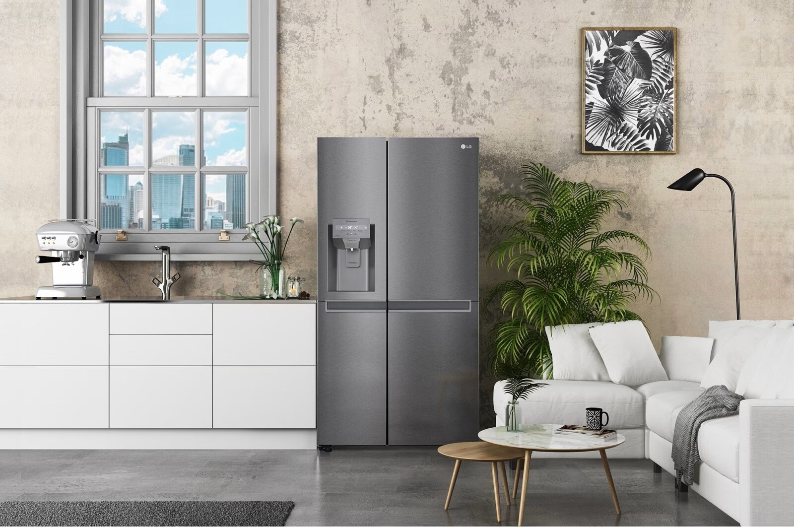 Cuisine moderne avec un réfrigérateur LG gris métallisé à deux portes, une machine à café élégante sur un plan de travail blanc et un salon attenant décoré avec des plantes et un canapé blanc confortable.