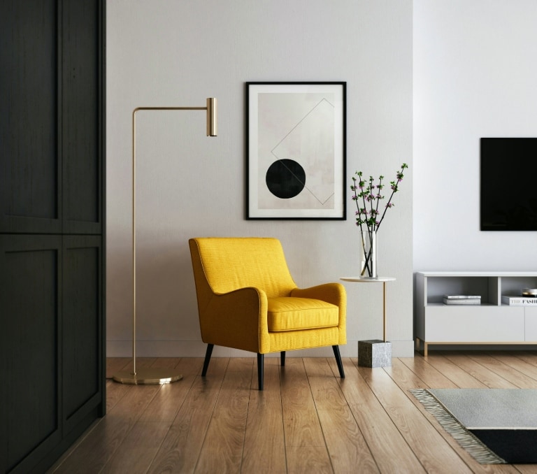 Un salon moderne dans une maison intelligente avec un fauteuil jaune, un tableau géométrique, un lampadaire et une télévision.