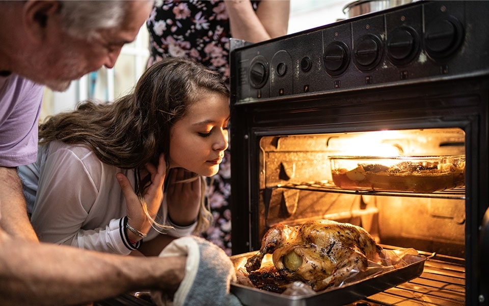 Femme qui sort un poulet du four