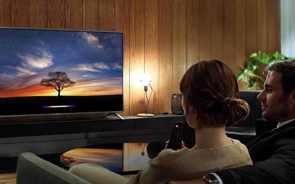 Un couple regarde le téléviseur LG dans sa salle de cinéma à domicile.