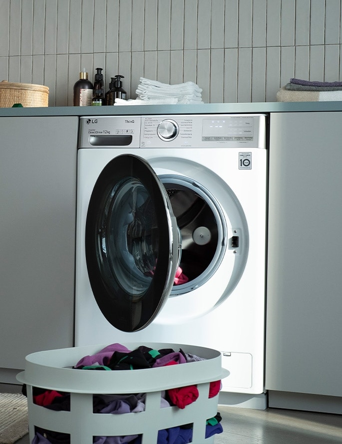 An image of LG Washing Machine with the door open and a laundry basket at the front.