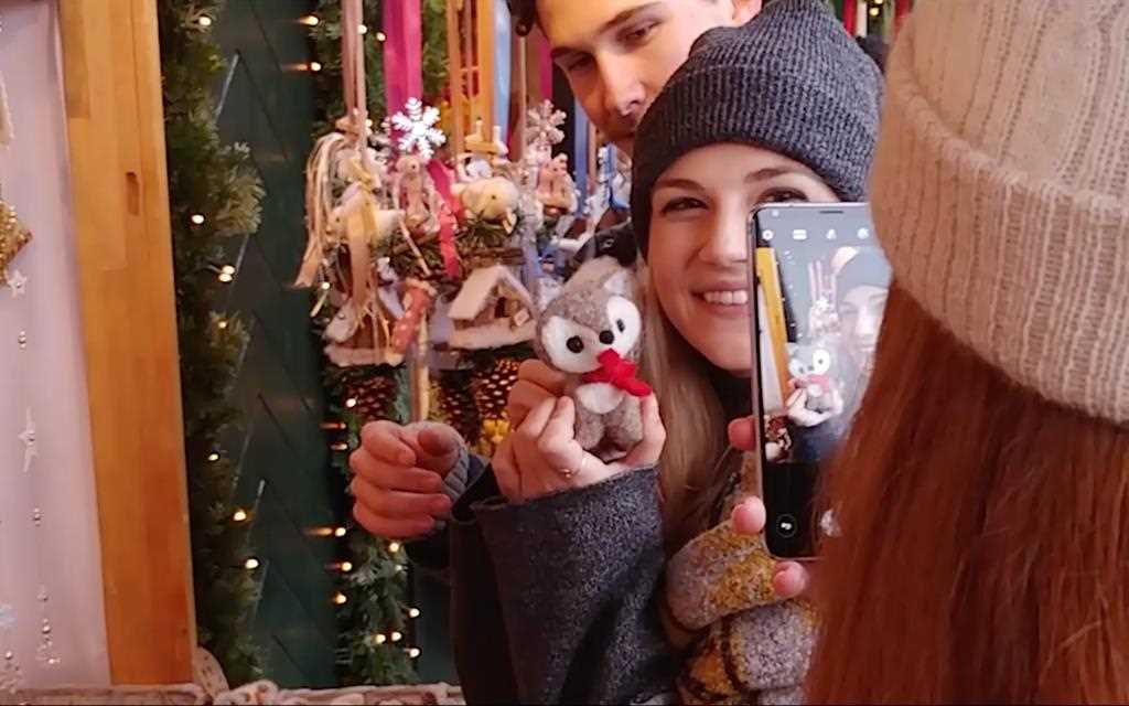 Friends use the LG V30 smartphone to take photos at the Christmas market.