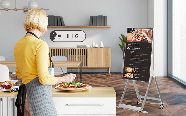 A woman is using voice commands to control the One:Quick Flex while cooking.
