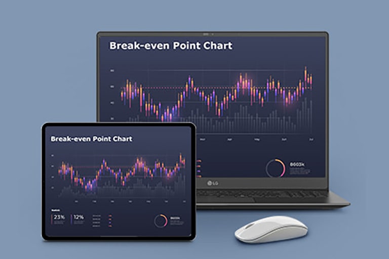 A gray laptop and a tablet side by side, both showing a "Break-even Point Chart" with a line graph in vibrant colors against a dark background. A wireless mouse is placed next to the laptop.	