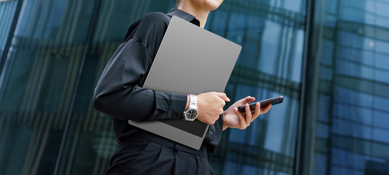 A woman is holding a phone in one hand and LG gram +view in the other.	