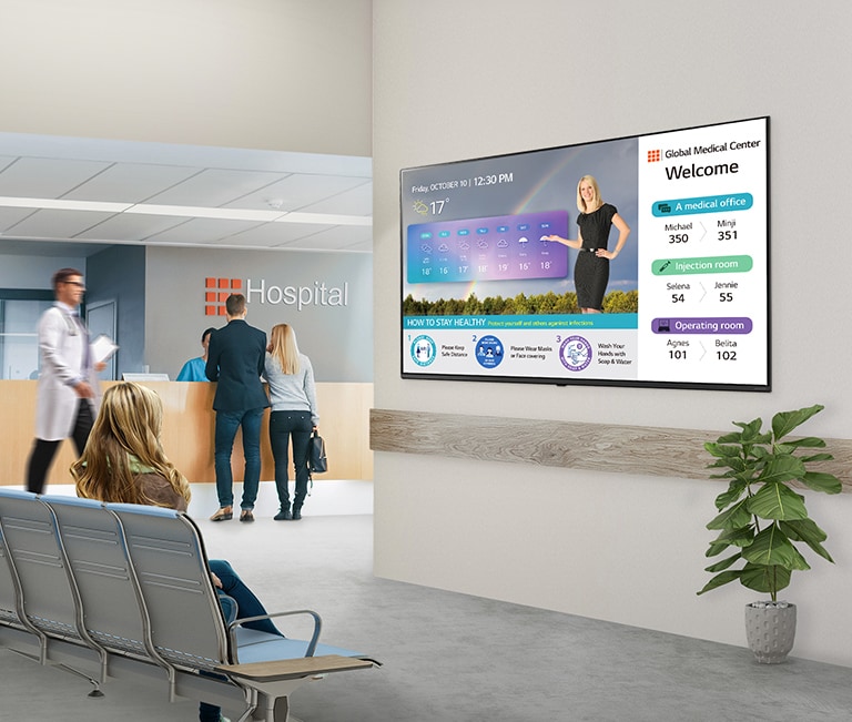 There is a TV set on the wall of the hospital lobby for waiting people.