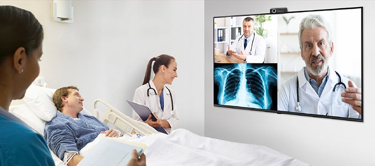 A doctor is giving web-based telemedicine to patient in the hospital room via TV.