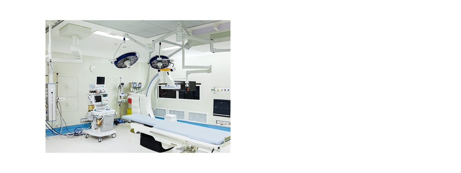 An operating room with an examination bed and various medical devices placed inside.