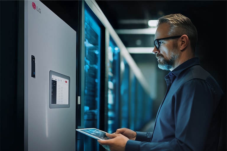 Engineer monitoring LG chiller plant system on a touchscreen panel in a data center environment.