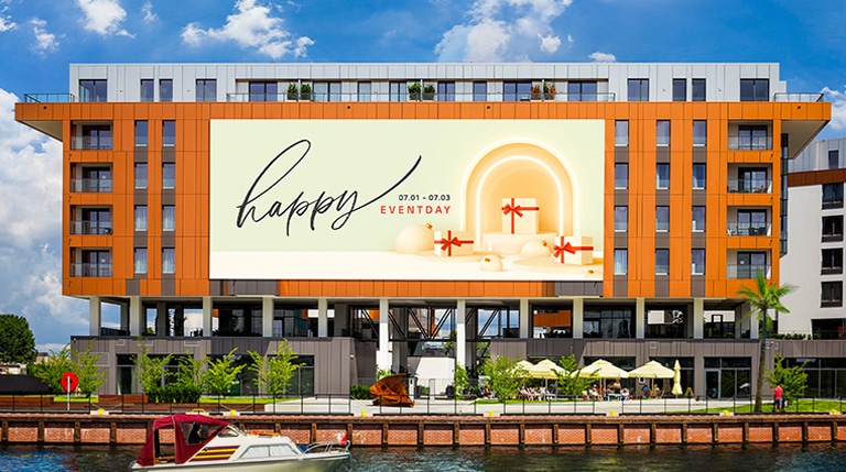 A large LED is installed on the 6th floor exterior wall of a building. Even in the strong sunlight, the screen’s contents are clearly visible.