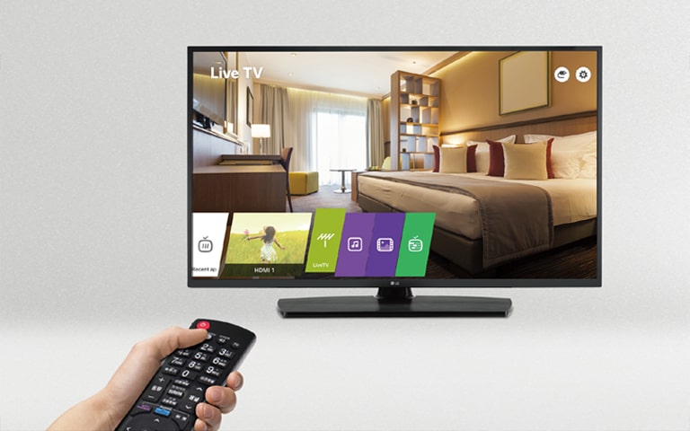 A person is controlling the TV settings with Public Display Mode.