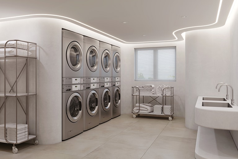 On premises with rows of lg washing machines and dryers. The interior features white walls, a curved ceiling, and a stainless steel sink.
