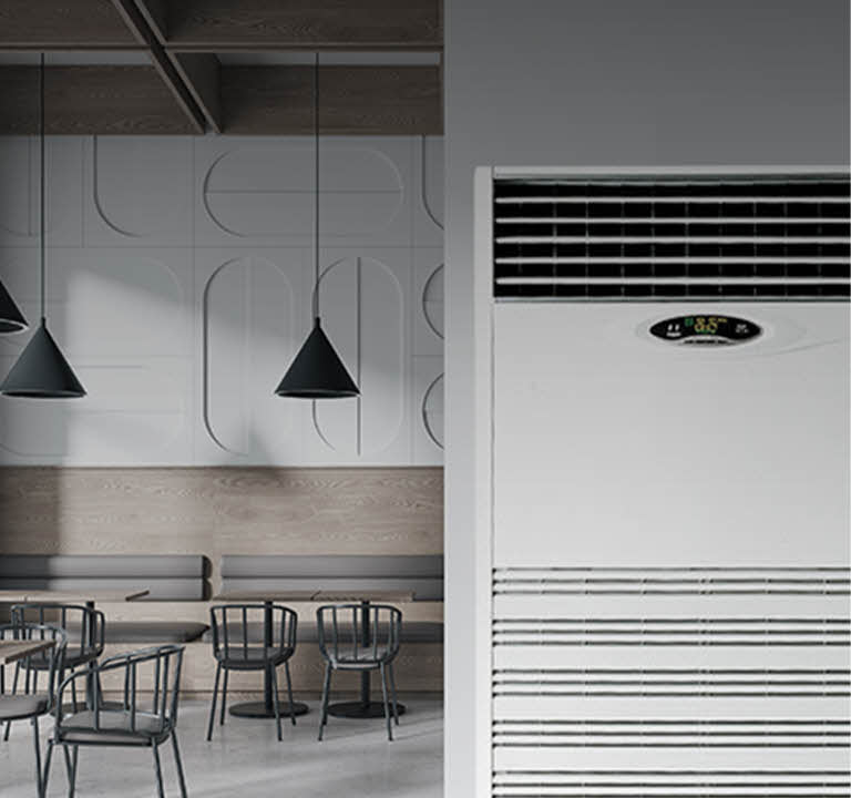 Close-up view of a large floor-standing air conditioner placed in a minimal commercial space, designed for high-capacity cooling in open public environments.