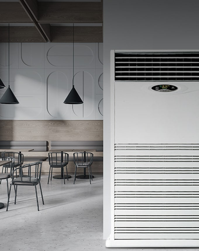 Close-up view of a large floor-standing air conditioner placed in a minimal commercial space, designed for high-capacity cooling in open public environments.