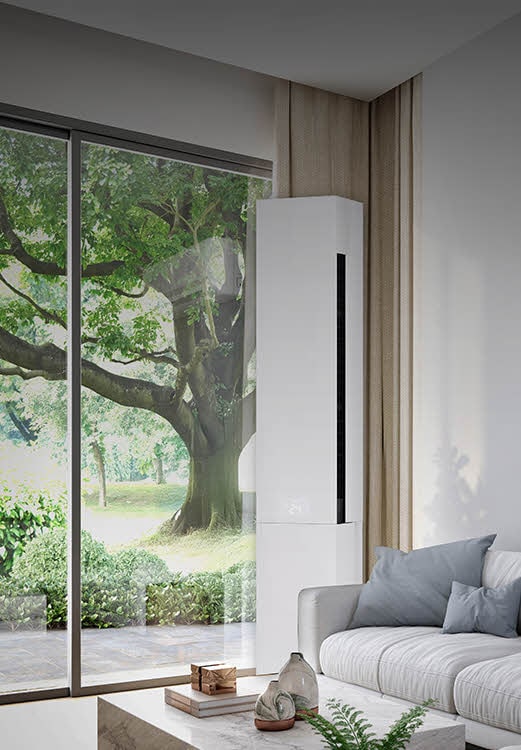 Bright living room with a large window and an floor-standing air conditioner installed beside a sofa, blending into the modern home interior for residential cooling.