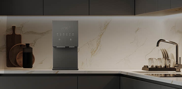 Minimalist kitchen counter with an hot and cold water purifier placed against a marble backsplash, delivering purified water with precise temperature control.