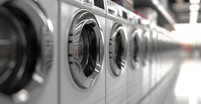 A row of silver color washing machines 