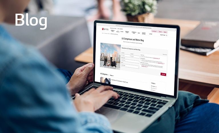 A man using a laptop to read LG Compressor's blog posts. You can click on the image to visit blog page