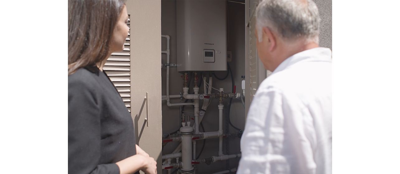 A woman and a man talking infront of water tank