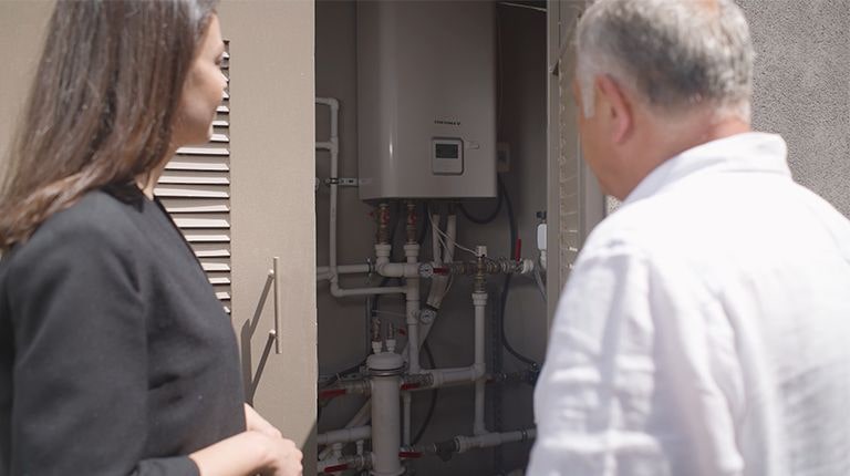A woman and a man talking infront of water tank