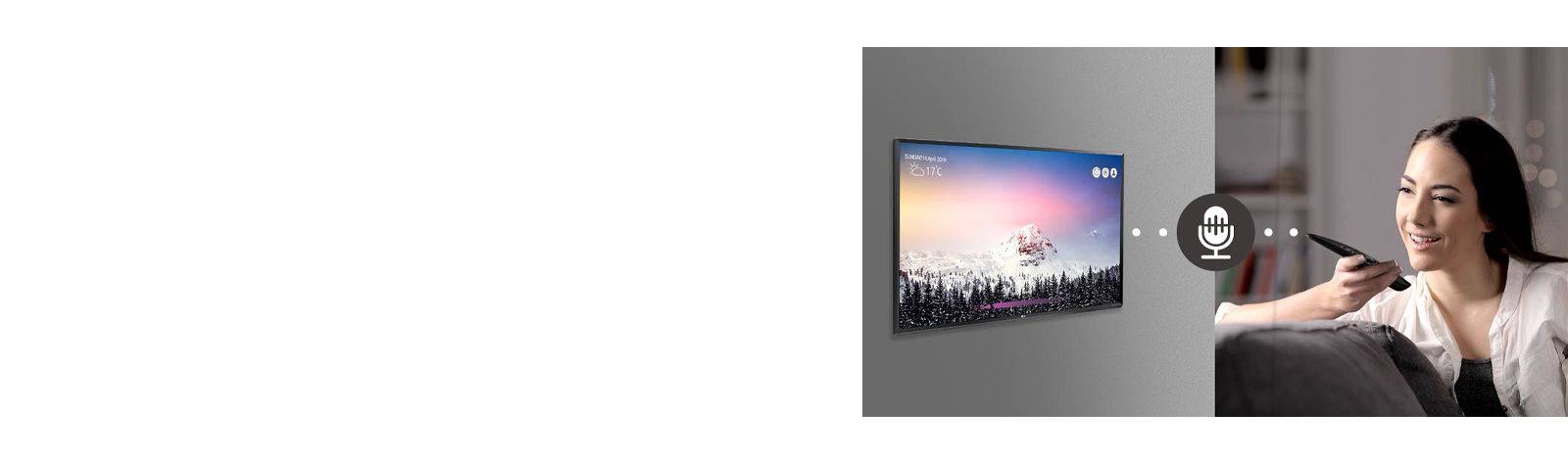 A woman is controlling TV by speaking to a remote control which has voice recognition.