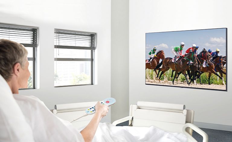 A patient in the hospital room is watching VOD on a TV hanging on the wall without a set-top box.