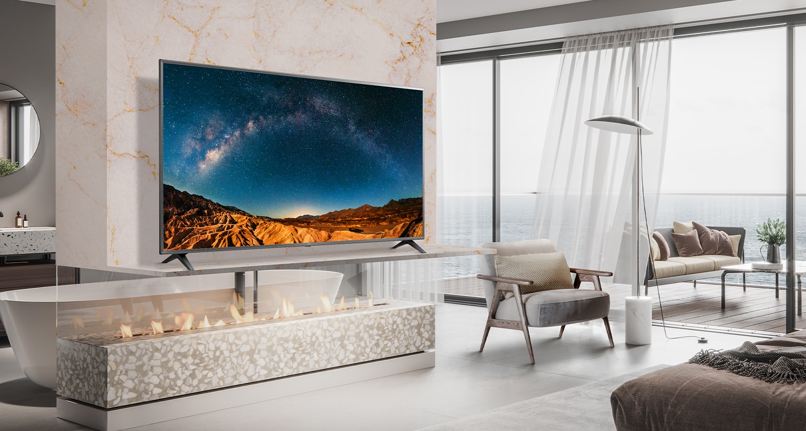 В простой спальне с видом на море на настенной полке стоит телевизор.  Голубой морской пейзаж на экране телевизора выглядит ярким и четким.
