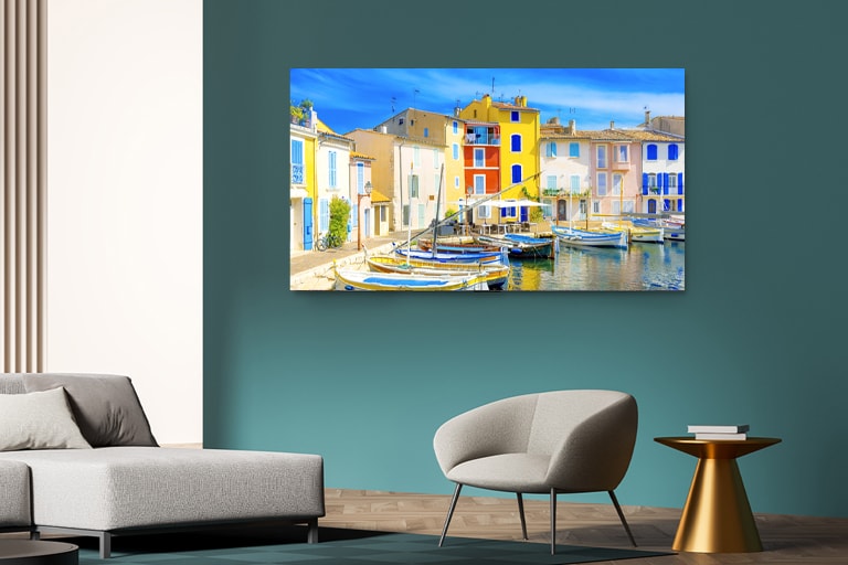 A TV is mounted on a hotel wall, displaying a colorful scene.