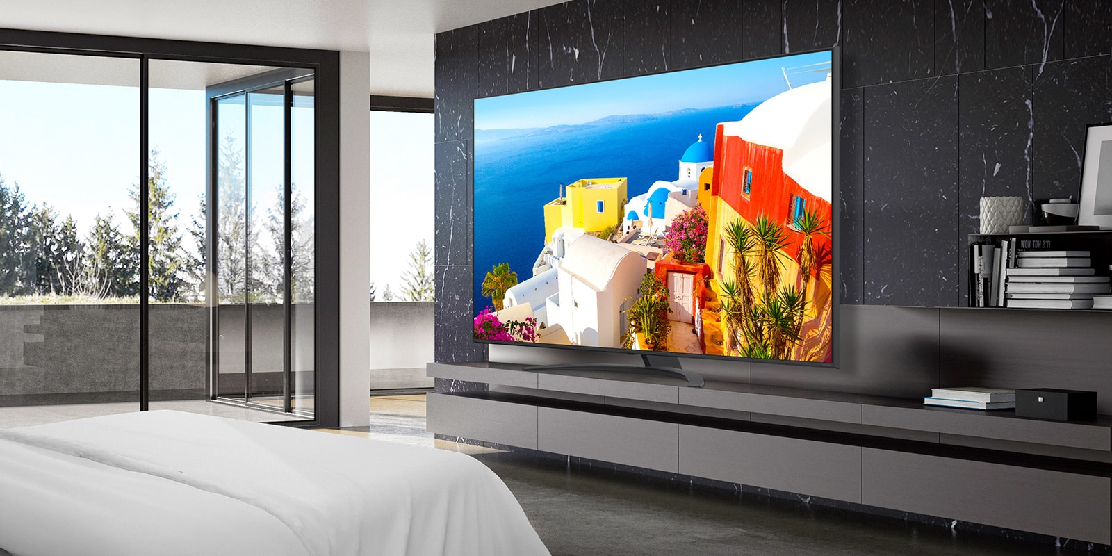 A TV is installed on a stand close to the wall in the hotel room, and the screen is bright and clear.