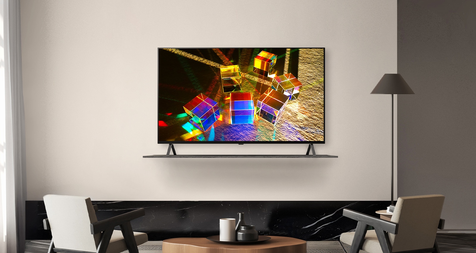 A TV is placed on a shelf on a hotel wall, and the screen vividly displays an image of objects reflecting colorful light.
