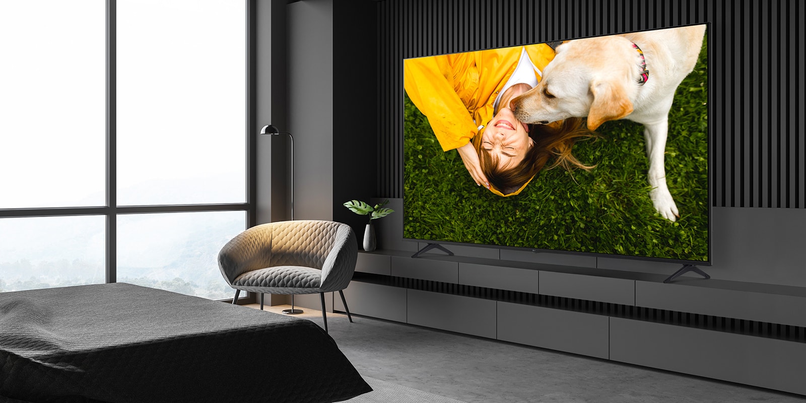 A TV is installed on a stand close to the wall in the hotel room, and the screen is bright and clear.