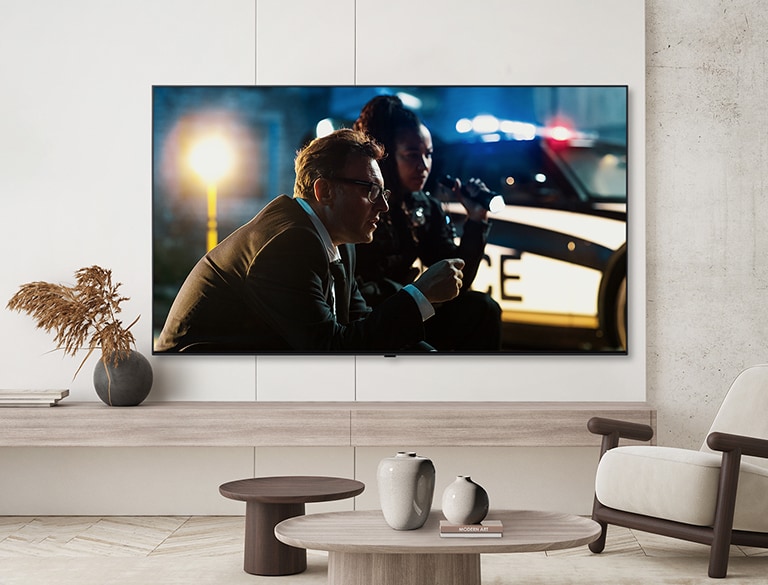 A TV by a hotel’s wall shows a bright and vivid screen.