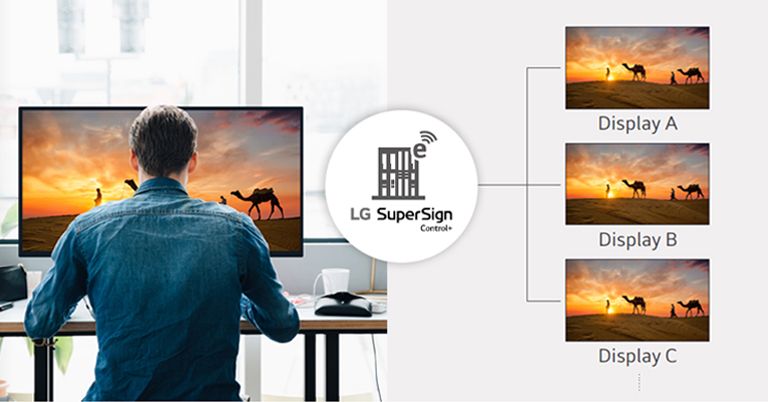 A man is managing several displays at once in his office using an LG SuperSign Control+ solution.