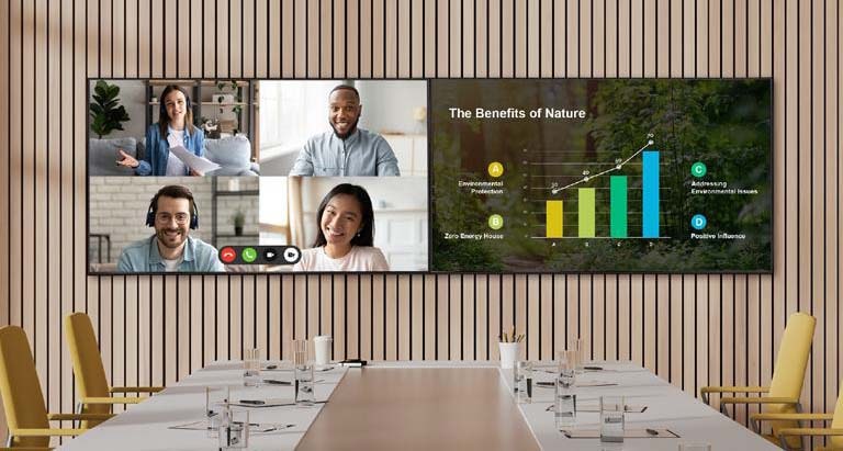 Two UP5Q-E displays are installed side by side in the meeting room. One display features a four-way multi-screen setup showing video conference participants, while the other presents meeting materials in full screen.