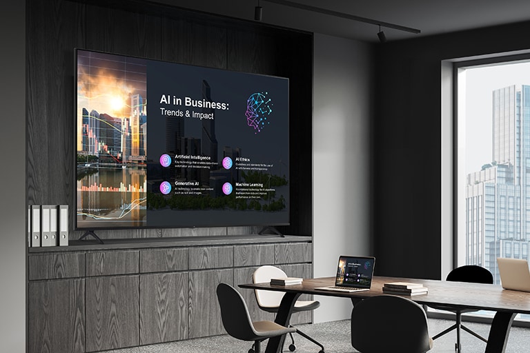 A TV Signage is installed in the meeting room, clearly showing the same meeting materials as those on a laptop screen placed on the table.