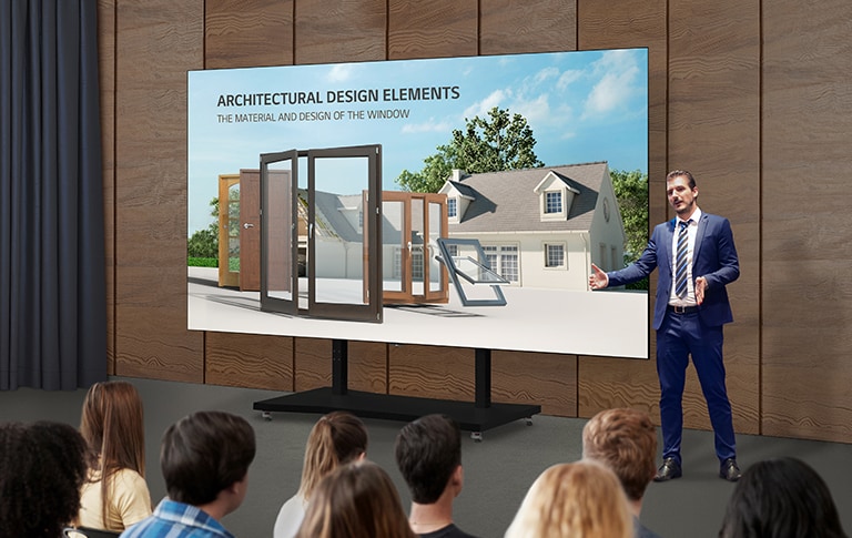 A man explains content on the screen of an LAEC installed with a dedicated stand in an auditorium.