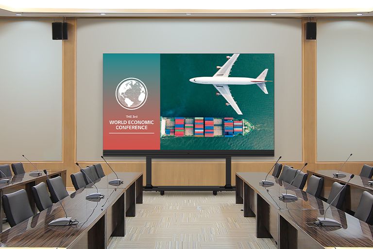 In a spacious meeting room with long tables on both sides, the LABB is placed on a stand in front of the wall. The LABB screen displays meeting content vividly.