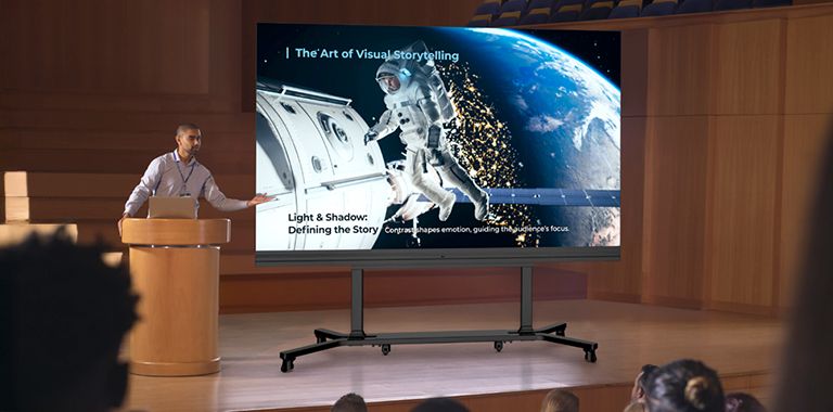 The LABB is placed on a dedicated stand at the lecture hall stage, vividly displaying class content on its high-contrast screen.