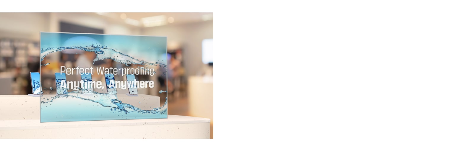 Transparent OLED Signage is installed in front of a table upon which cell phones are displayed in a cell phone store. The Transparent OLED Signage screen is showing an advertisement, and the cell phones displayed behind the screen are also clearly visible.