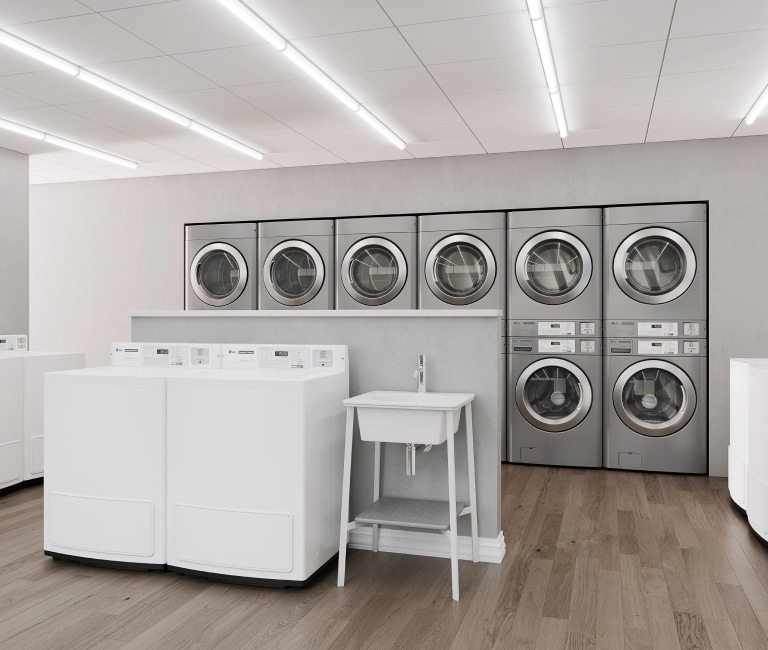 LG commercial laundry setup with stackable front-load washers and dryers, top-load washers, and a sink, providing an efficient laundry solution.