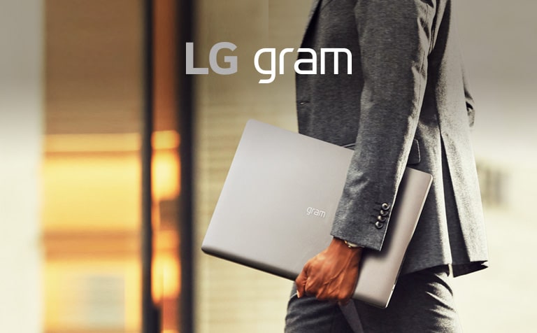 A business man is holding LG gram 17 easily with one hand.