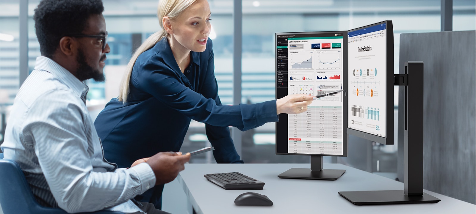 Two male and female employees discuss while looking at the monitor in the office.	