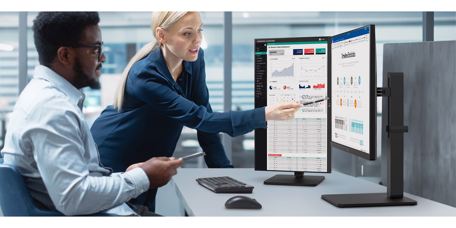 Two male and female employees discuss while looking at the monitor in the office.	