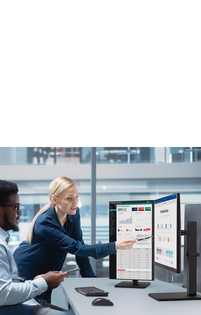 Two male and female employees discuss while looking at the monitor in the office.	